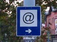 Black &ldquo;at&rdquo; sign in white square on blue background, with white arrow pointing right